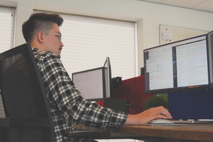 Developer kijkt naar twee beeldschermen